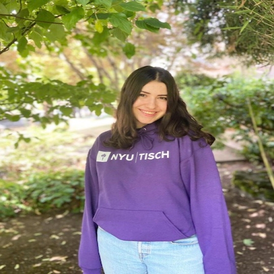 Talia Berniker in NYU sweatshirt in front of trees